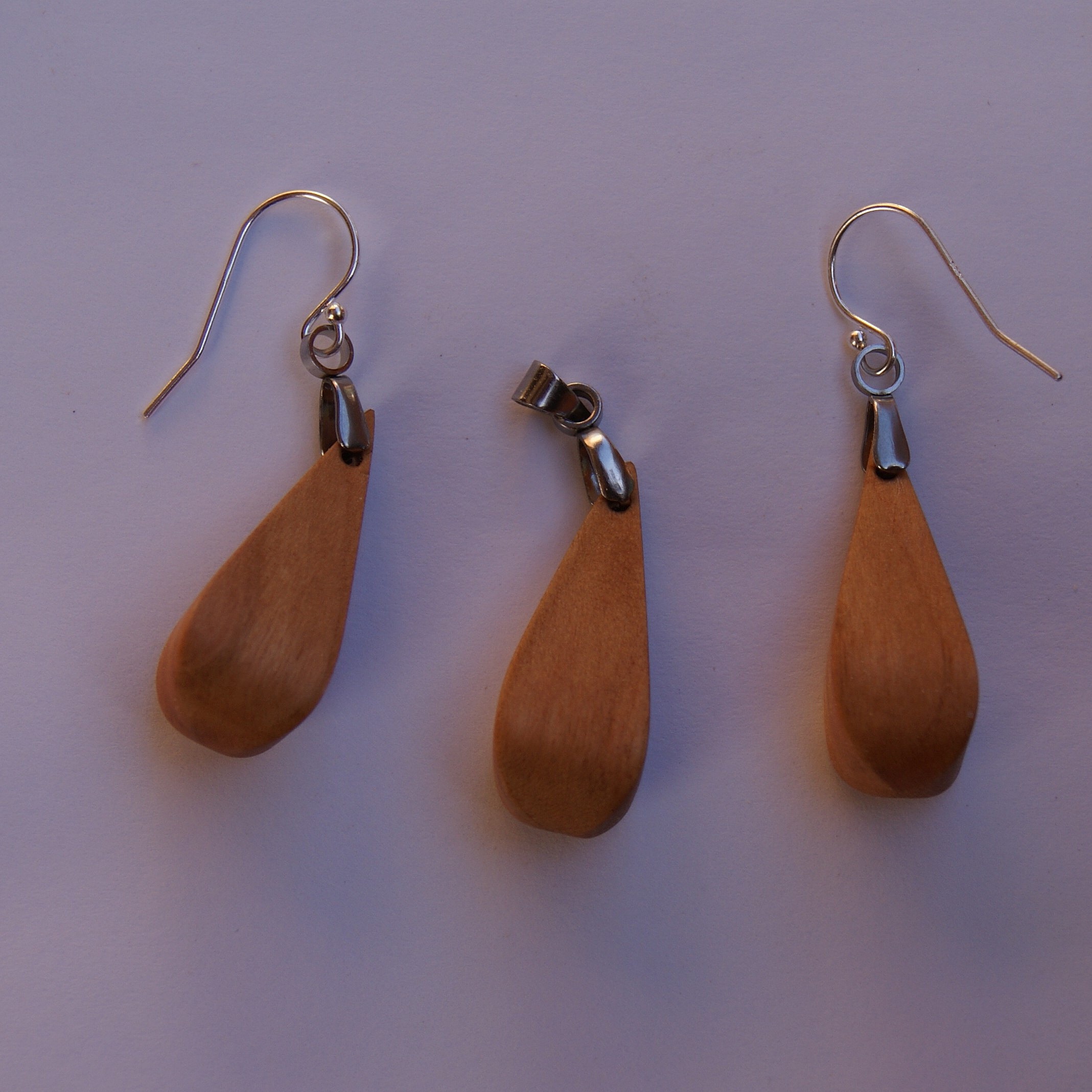Pendentif gouttelette 3D en bois artisanal sur cordon noir.